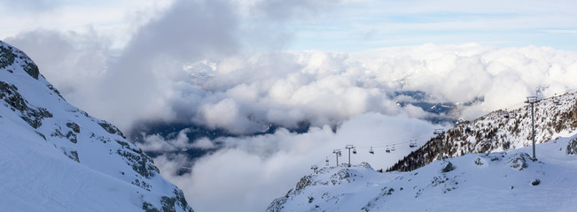 Whistler Ski Resort, British Columbia, Canada. Beautiful Panoramic View of the snowy Canadian Nature Landscape Mountain and Chairlift going to the peak during a vibrant winter morning.