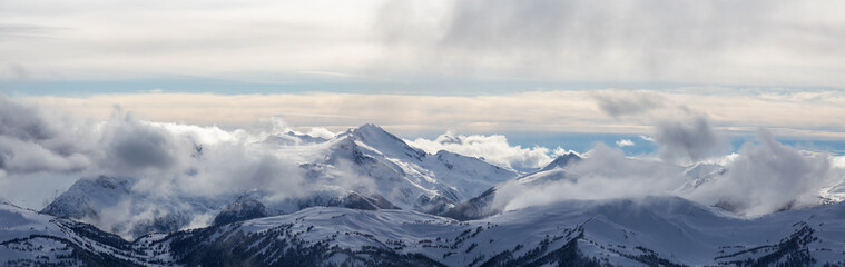 Fototapeta na wymiar Whistler, British Columbia, Canada. Beautiful Panoramic View of the Canadian Snow Covered Mountain Landscape during a cloudy and vibrant winter day.