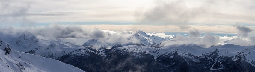 Fototapeta na wymiar Whistler, British Columbia, Canada. Beautiful Panoramic View of the Canadian Snow Covered Mountain Landscape during a cloudy and vibrant winter day.