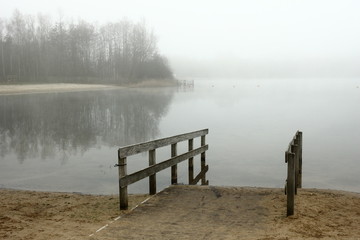 Foggy, wintery images of a lake: the Plas in Rotselaar in Flanders, Belgium. On the image a slope for disabled .