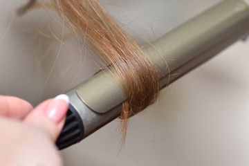 Close-up female hair and curler for creating curly hair. Hair health concept