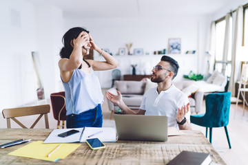 Dark haired bearded man making excuses to young upset woman