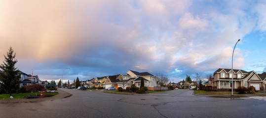 Residential Suburban Neighborhood in the City during a vibrant winter sunset. Taken in Fraser Heights, Surrey, Vancouver, BC, Canada. Panorama, Wide Angle