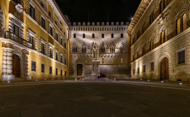 Monument Sallustio Bandini and Salimbeni palace on Piazza Salimbeni at night, Siena, Tuscany, Italy.
