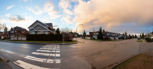 Residential Suburban Neighborhood in the City during a vibrant winter sunset. Taken in Fraser Heights, Surrey, Vancouver, BC, Canada. Panorama, Wide Angle