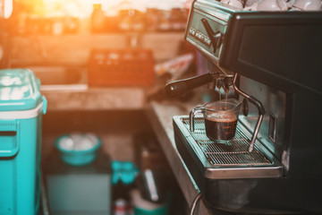 coffee machine prepares American coffees and pour them into a glass cup in the coffee shop.