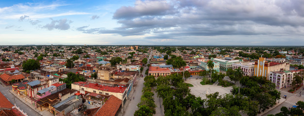 Ciego de Avila, Cuba - June 14, 2019: Aerial Panoramic view of a small Cuban Town during a cloudy and colorful sunset.