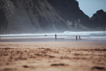 Fototapeta na wymiar children playing on beach silhouettes
