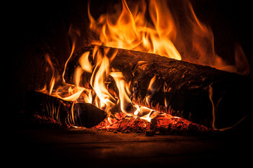 Burning wood inside traditional pizza oven