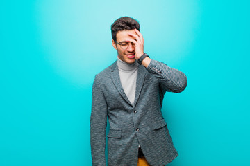 young arabian man laughing and slapping forehead like saying d‚Äôoh! I forgot or that was a...