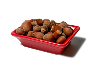 Hazelnuts in a red rectangular saucer isolated on white background. Close-up