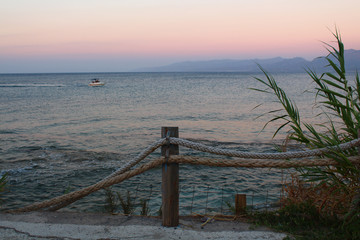 Naklejka premium Greece, Crete. Sea promenade in the evening. Rope fence on the promenade by the sea.