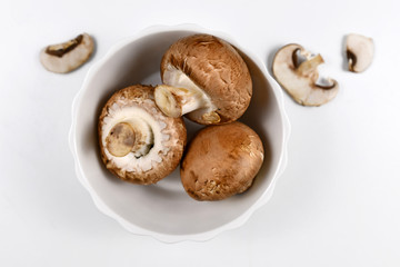 Brown button mushrooms in white bowl