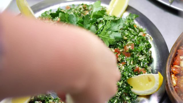 Couscous salad with parsley leaves, green dill, slices of tomato and lemon. Healthy homemade veggies salad. Diet or vegan food, vitamin snack concept