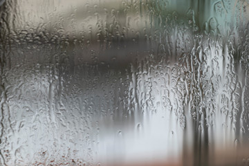 Rainy weather, raindrops on the glass of window, water drips wet. Texture, background.