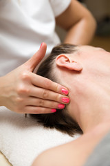 Woman getting a stress relieving pressure point massage on her neck by a health therapist