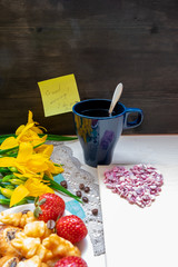Valentine's day strawberry cookies hearts with coffee, with yellow flowers on a napkin, Notepad with a pen, a note with the text Good morning, I love you