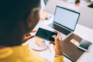 Faceless lady taking dessert using cellphone