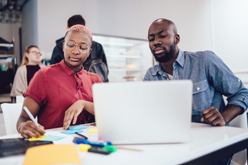 African American colleagues working together on laptop