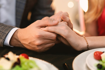 Closeup Of Romantic Couple Holding Hands On Date Dinner In Restaurant