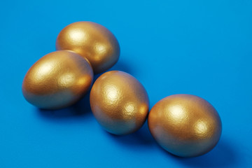Golden eggs on a blue surface