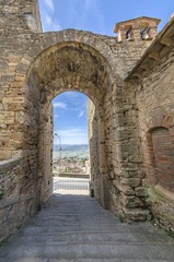 Ancient village with passage under archway in Tuscany