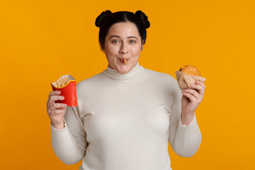 Funny Fat Girl Eating Burger And French Fries On Yellow Background