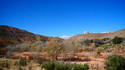 Bright landscape of Morocco, breathtaking curves of mountains, stunning combination of hills & farm land,inadvertent distribution of houses & huts, raw impression of pure nature.