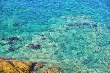 Amazing azure sea water and rocks. Beautiful natural beach with white stones and turquoise water. Halkidiki Greece Blue Flag Beach. Coral reef in the sea. White rocks and blue transparent ocean 