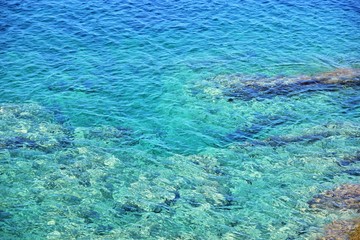 Amazing azure sea water and rocks. Beautiful natural beach with white stones and turquoise water. Halkidiki Greece Blue Flag Beach. Coral reef in the sea. White rocks and blue transparent ocean 