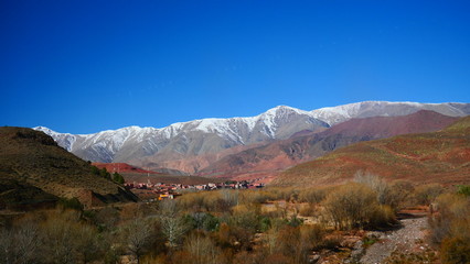 Fototapeta premium Bright landscape of Morocco, breathtaking curves of mountains, stunning combination of hills & farm land,inadvertent distribution of houses & huts, raw impression of pure nature.