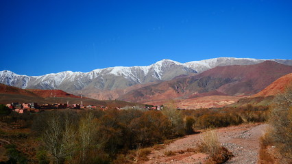 Fototapeta premium Bright landscape of Morocco, breathtaking curves of mountains, stunning combination of hills & farm land,inadvertent distribution of houses & huts, raw impression of pure nature.