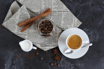 Obraz na płótnie Canvas Coffee with cream, cinnamon on a dark background. Background image, copy space