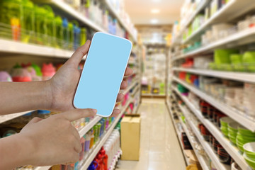 Hand hold a smart phone to buy or pay money at supermarket . technology concept.