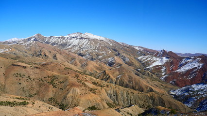 Fototapeta premium Bright landscape of Morocco, breathtaking curves of mountains, stunning combination of hills & farm land,inadvertent distribution of houses & huts, raw impression of pure nature.