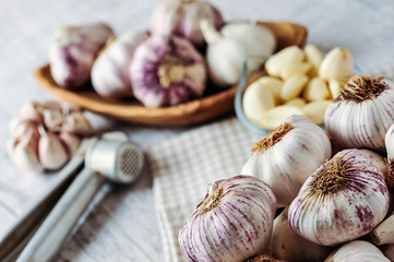 Garlic Cloves and Bulb in wooden bowl on white table.