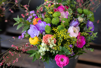 Colorful spring bouquet from fresh cut flowers - freesia, chrysanthemums, persian buttercups, sea lavender - flowers gift.