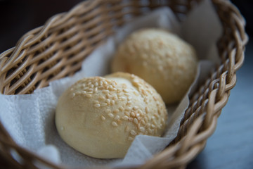 Fototapeta na wymiar Two sesame buns are in the bread basket. Bread close-up.