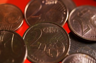 Makro close up of pile one and two euro cent copper coins on shiny red background
