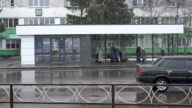 Belaya Tserkov, Ukraine, January 04, 2020: people hide from wet snow at a bus stop while waiting for transport.
