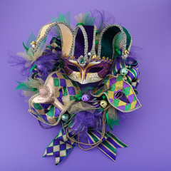 Mardi gras wreath on purple background with mardi gras mask. Top view