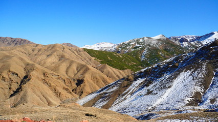 Fototapeta premium Bright landscape of Morocco, breathtaking curves of mountains, stunning combination of hills & farm land,inadvertent distribution of houses & huts, raw impression of pure nature.