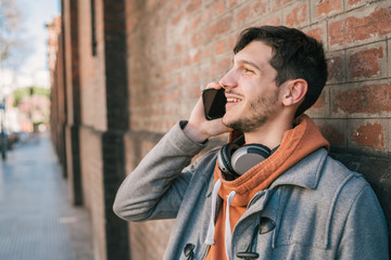 Young man talking on the phone outdoors.