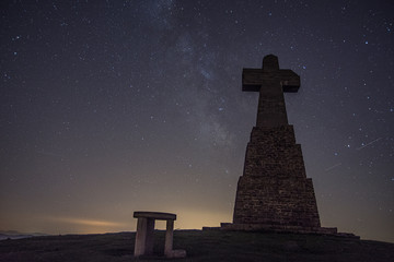 cross in a mountain summit under the stars,  basque country