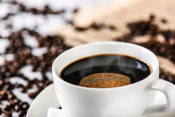 Coffee cup and beans on old white table. Roasted coffee beans top view.