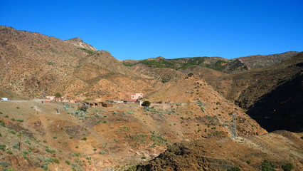 Bright landscape of Morocco, breathtaking curves of mountains, stunning combination of hills & farm land,inadvertent distribution of houses & huts, raw impression of pure nature.