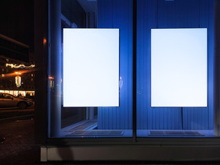 advertising poster in the window on the display window glowing. on a blue background in the late...