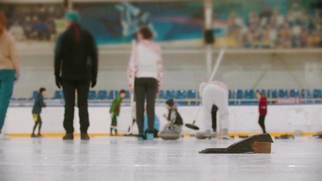 Curling training in the sport complex - different people training on the background