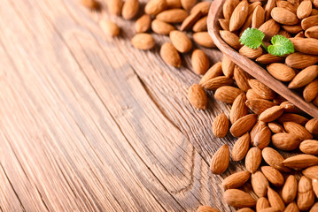 Almond nuts on wooden table top view. Fresh almonds copy space.