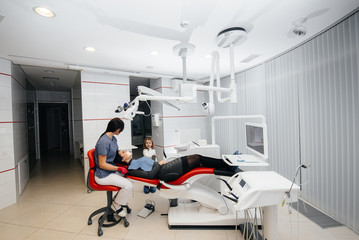 A little girl supports her mother during treatment at the dentist